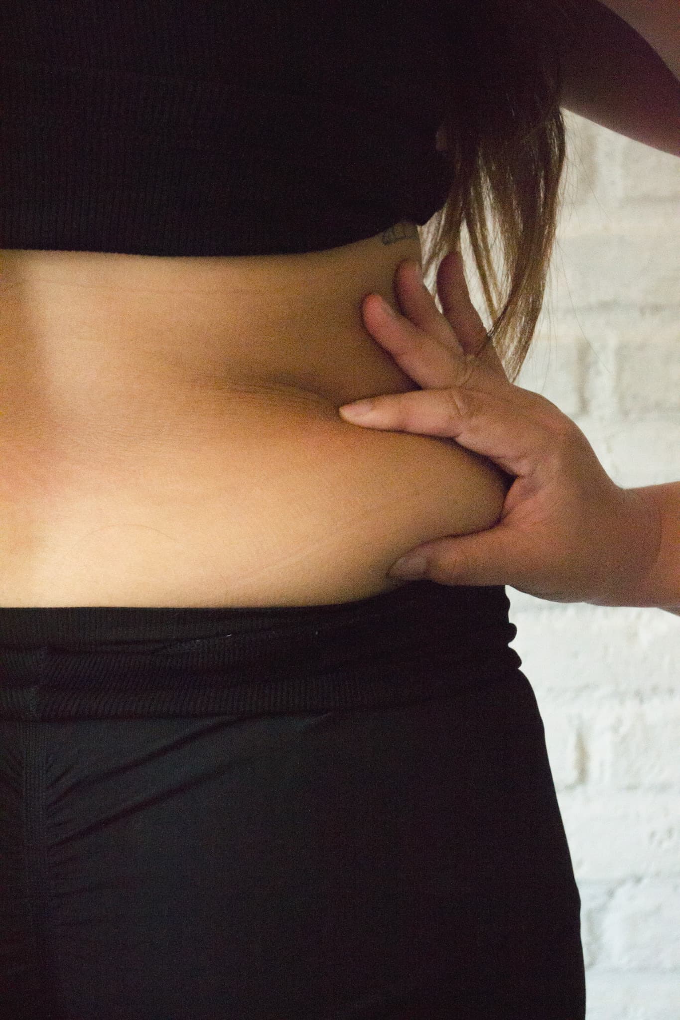 A close view of a hand assessing the waist area.